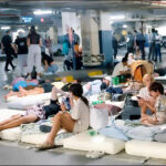 People and tourists take shelter inside a hotel parking garage in Dubai, United Arab Emirates, after drone and missile strikes hit the city, March 2026