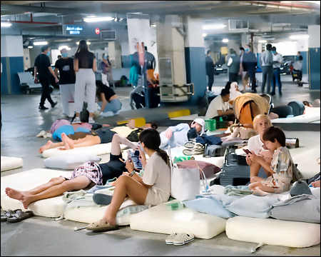 People and tourists take shelter inside a hotel parking garage in Dubai, United Arab Emirates, after drone and missile strikes hit the city, March 2026